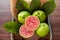 Closeup on red guava sliced with green leaf on rustic wooden background