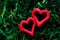 Closeup of red hearts on green moss background