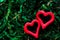 Closeup of red hearts on green moss background