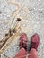 Closeup of Red Leather Boots  and  Corduroy Pants,  with a Bunch of Dry Grasses, Grey Gravel