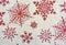 Closeup of red sparkling snowflakes on a white surface
