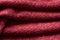 Closeup red texture of woolen knitted fabric. Pattern of several layers of red fabric