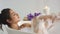 Closeup relaxed woman washing body with foam at home bath. Woman blowing foam