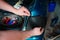 Closeup repairing of an broken blue car in garage by hands of machanic