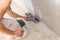 Closeup of repairman hand plastering a wall with putty knife or spatula.