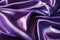 Closeup of rippled purple satin fabric texture background