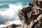Closeup Of Rock On Ocean Cliff Against Backdrop Of Unfocused Crashing Waves. Generative AI