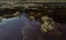 Closeup of rocks in red acidic and polluted Rio Tinto River due to mining, in Spain