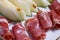 Closeup of rolled slices of cured pork ham jamon with melon