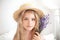 Closeup romantic portrait Charming little blond girl in a straw hat holds a bouquet of lavender. Summer flowers, aromatherapy. An