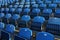 Closeup of rows of blue folded chairs at a stadium