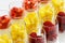 Closeup of rows of fruit and cream desserts in glass flutes on w