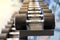 Closeup rows of metal dumbbells on rack in the gym