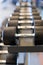 Closeup rows of metal dumbbells on rack in the gym