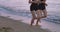 Closeup running legs of a two ladies through the beach in the morning wearing sportswear. 4k