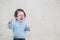 Closeup sad asian kid cry because he want something on marble stone wall textured background with copy space