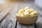 Closeup salted popcorn in round wooden bowl on wooden floor with vintage flare light