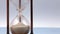 Closeup of a sand clock on the left side with space on the right side. Closeup of a glass sand clock on white with