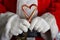 Closeup of Santa Claus hands holding two old fashioned candy canes forming a heart shape