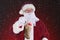 Closeup of Santa Claus holding a burlap Christmas Stocking, on a light to dark red background with snow effect