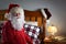 Closeup of Santa Claus wearing a red union suit sitting on the edge of his bed at the North Pole, ready to go to sleep after