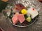 Closeup of sashimi set served with wasabi and ice surrounded on a silverware plate