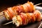 closeup of scallop skewer wrapped with crispy bacon