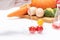 Closeup of a scientist adding toxic substances to cherry tomatoes against a white background