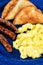 Closeup of a scrambled eggs breakfast with toast and three sausage links