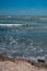 Closeup of sea frothy waves rushing towards the shore, scenic waterscape on the background