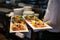 Closeup of seafood and meat with vegetables on white plates in the hands of the waiter