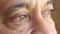 Closeup of a senior mans eyes thinking about past memory and mourning, wishing or longing for peace while feeling lonely