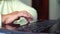 Closeup senior old woman hand on laptop keyboard surfing internet at home with free and copy space