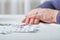 Closeup senior woman hands with pills and coins  on table at home. An elderly pensioner counts money