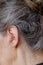 Closeup senior woman inserting hearing aid in her ears