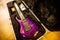 Closeup of a seven-string purple electric guitar in a black box casing