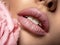 Closeup sexy female lips with pearl lipstick. Women`s lips and pearl flower