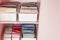 Closeup shelves pink female childish closet with neatly folded clothes Marie Kondo vertical storage