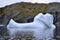 Closeup of shoe-shaped iceberg next to rugged cliffs in Twillingate Harbour