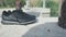 Closeup of shoes on background of barefoot person. Stock. Man took off his shoes and went to water barefoot. Hot summer