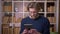 Closeup shoot of adult attractive male student using the tablet in the university library indoors