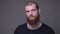 Closeup shoot of adult handsome muscular caucasian man with beard looking at camera with aggression with background