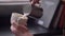 Closeup shoot of barista pouring milk into a steaming coffee in a cup using the silver pitcher in a cafe indoors