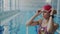 Closeup shoot of confident female swimmer putting on goggles on her face for underwater floating, She wear swimsuit and