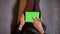 Closeup shoot of seductive fashion social media influencer using the tablet with green screen. Womans thighs in cute
