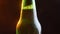 Closeup shoot of shining beer bottle neck rotating around in motion