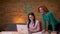 Closeup shoot of two businesswomen discussing dataon the laptop indoors in the office. Businessman passing by and