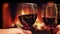 Closeup shoot of two hands clinking glasseswith red wine celebrating a night date with cozy warm fireplace on the