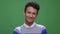 Closeup shoot of young attractive indian male smiling happily looking at camera with background isolated on green