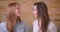 Closeup shoot of young beautiful lesbian couple smiling happily looking at camera sitting on the couch in a newly bought